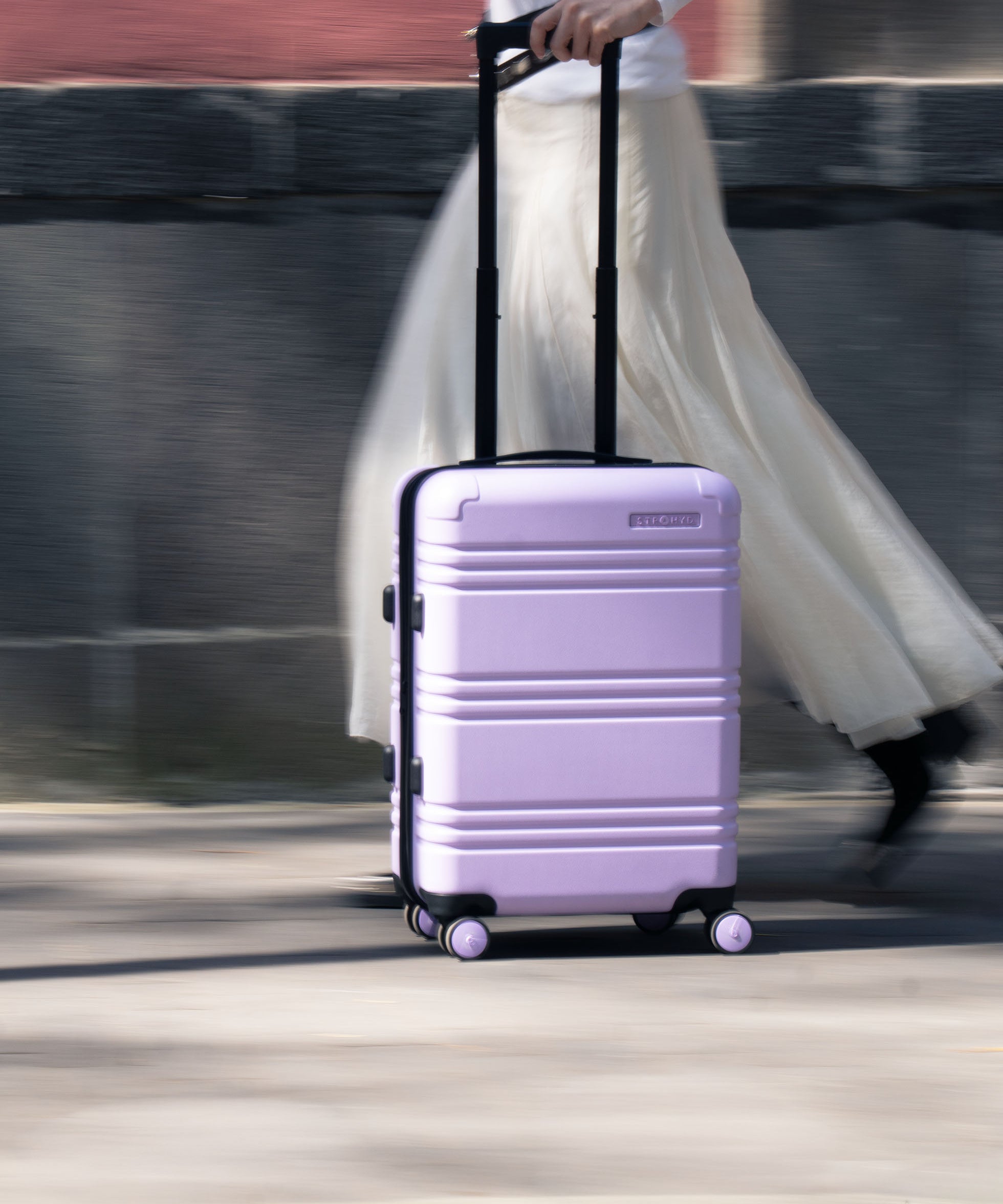 maleta carry on de cabina color lila en calle